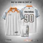 Áo đá banh White Beast không logo màu trắng phối họa tiết sóng xám, điểm nhấn nanh thú trên vai và cổ cam nổi bật, thiết kế hiện đại, sắc nét, dành cho đội bóng mạnh mẽ và khác biệt.