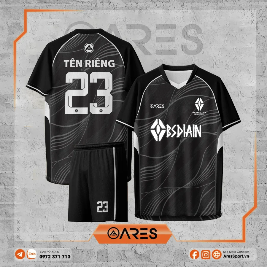 Áo đá banh thiết kế Obsidian Nightwave màu đen xám, họa tiết sóng uốn lượn hiện đại, phối logo BSDAIN trắng nổi bật và số áo lớn sau lưng, dành cho đội bóng doanh nghiệp yêu phong cách công nghệ, lạnh mà rất chất.