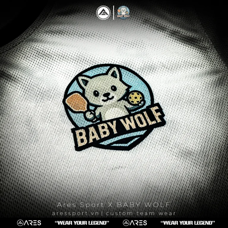 Ảnh chụp thật logo sói con cầm vợt thêu chỉ nhiều màu trên áo pickleball Baby Wolf Pleiku
