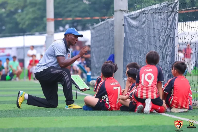 Áo coach bóng đá: 18 mẫu polo huấn luyện viên của 4 hãng lớn và cách chọn cho đội mình Áo huấn luyện viên bóng đá ARES in chữ TFA khi HLV hướng dẫn chiến thuật cho cầu thủ nhí