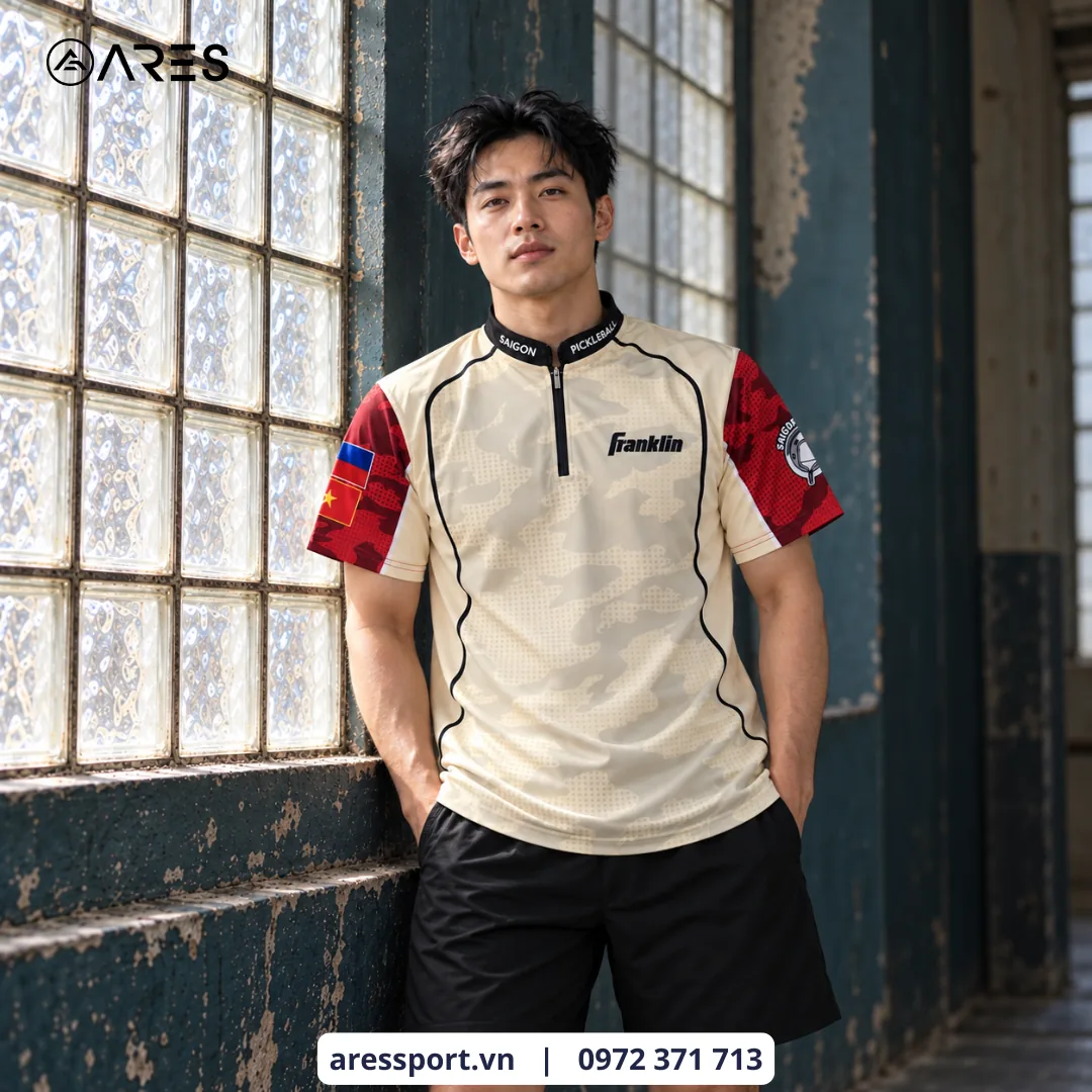 Ảnh minh họa áo lên người do AD dựng cảnh: người mẫu mặc áo pickleball cổ khóa kéo Saigon Pickleball ARES may bằng vải Mè Thái Pro, cạnh khung cửa kính khối